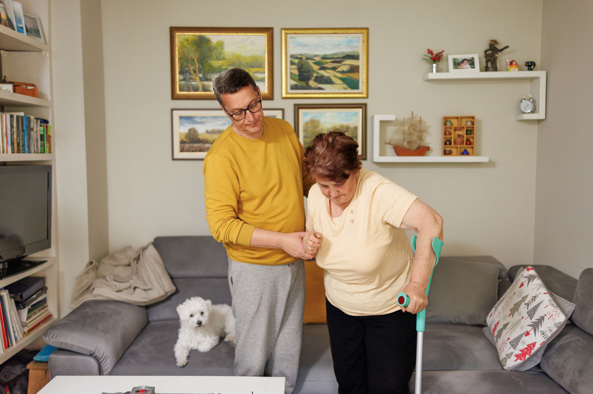 Son Assisting Elderly Mom with Crutches